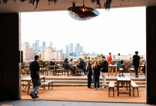 London riverside terrace bar, Smoke and Mirrors. People enjoying drinks with a stunning view over the River Thames of the City.